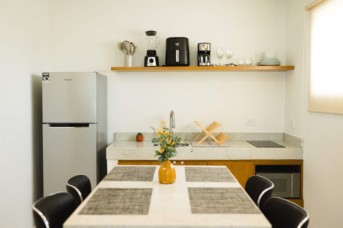 Cocina con refrigerador y comedor